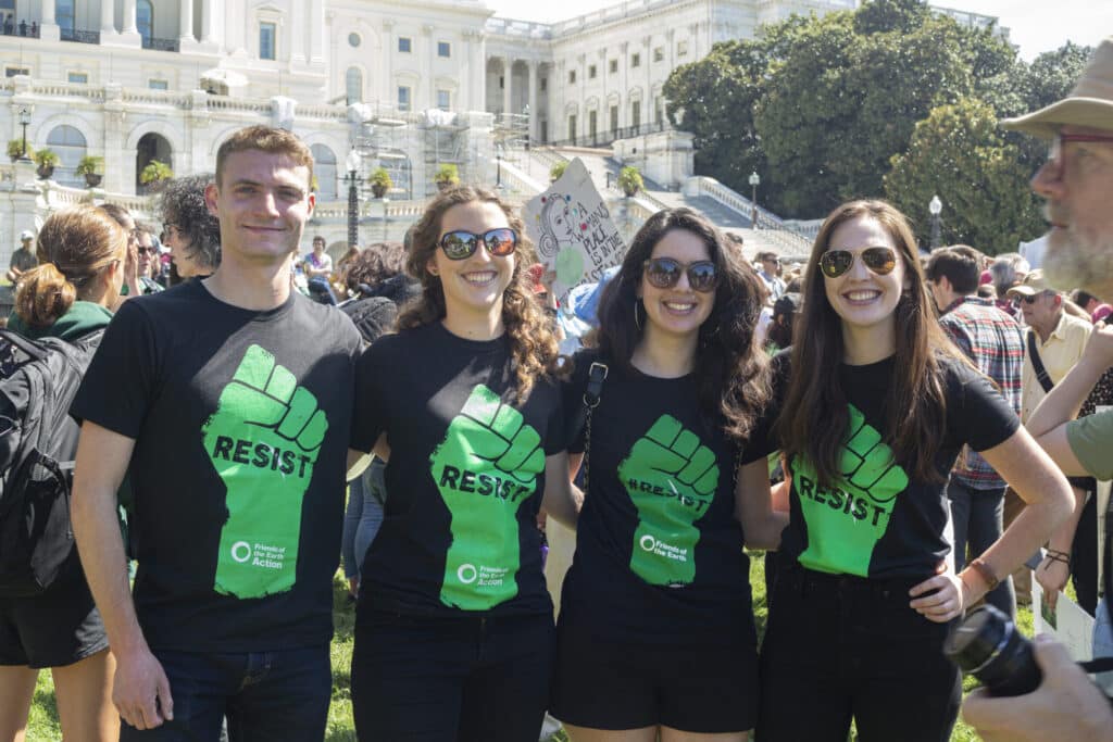 May contain four people wearing black t-shirts with green fists.